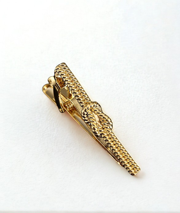 Gold tie clip on a white background
