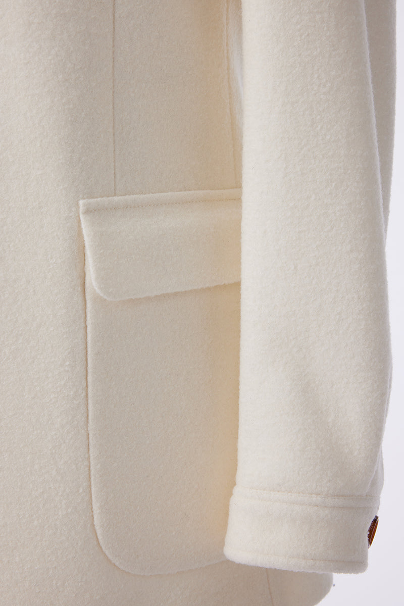 Close-up of a cream-colored coat with a pocket on a white background