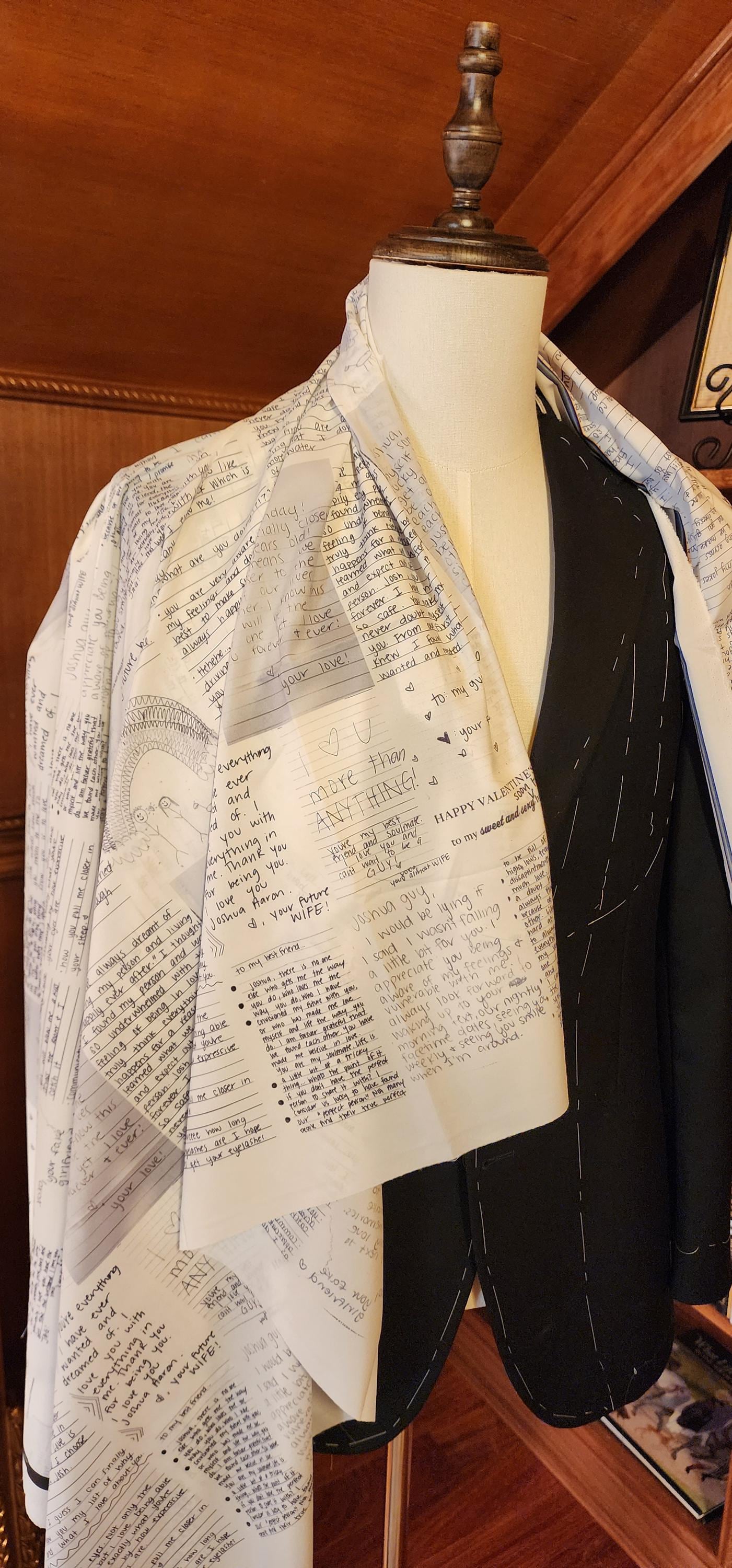 Mannequin wearing a jacket with a custom notes suit lining design against a wooden background