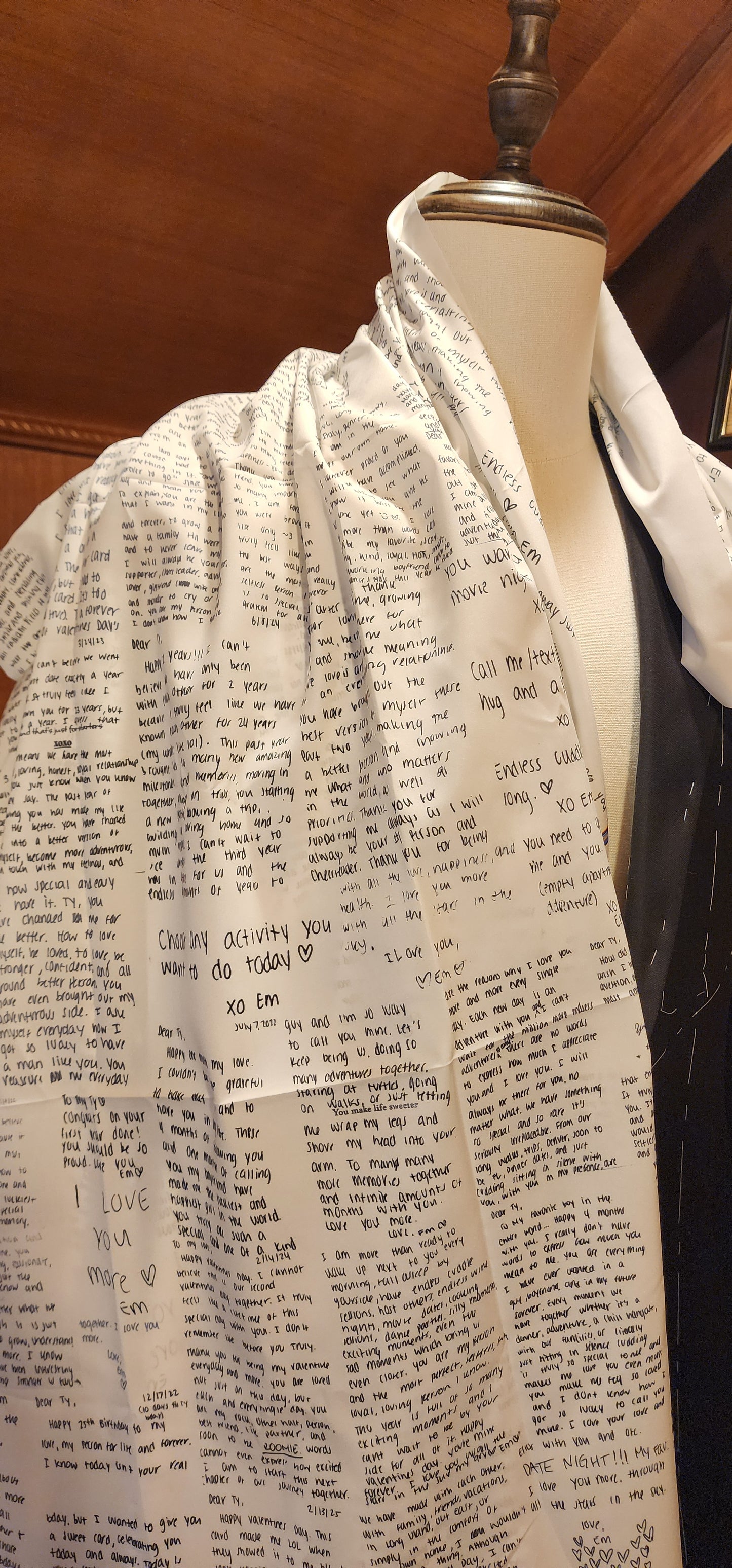 Mannequin wearing a dress with custom text suit lining on a wooden floor