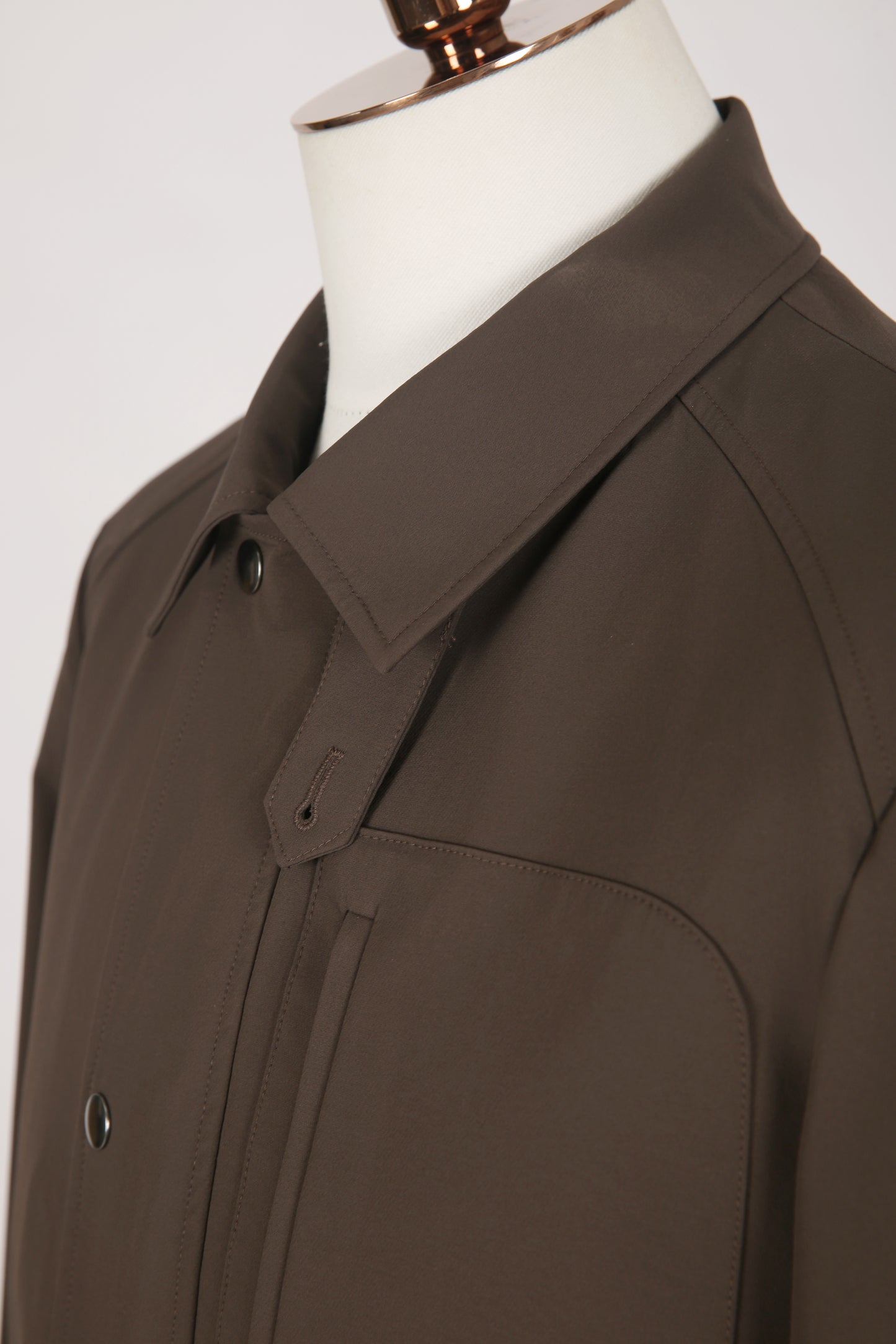 Brown coat on a mannequin against a white background