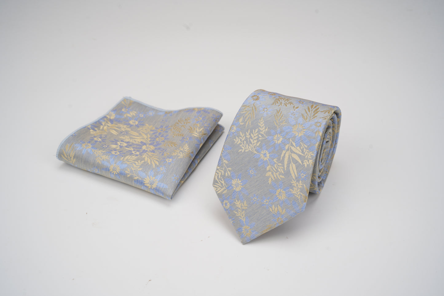 Gray tie with gold floral pattern on a white background