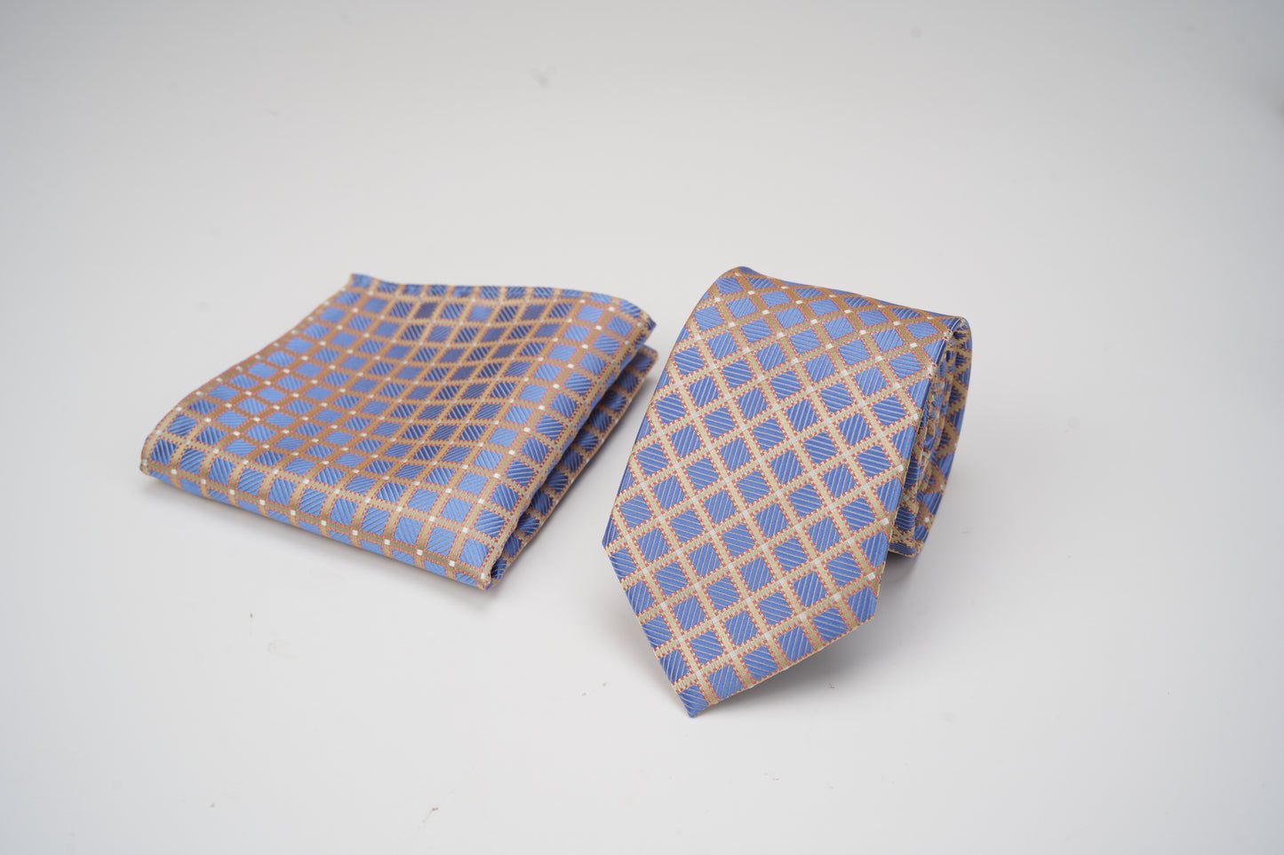 Blue and beige checkered tie and pocket square on a white background