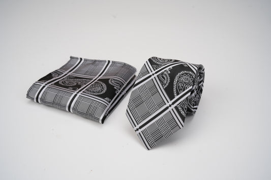 Black and white patterned tie and pocket square on a light gray background