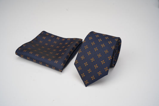 Navy blue tie and pocket square with gold pattern on a white background