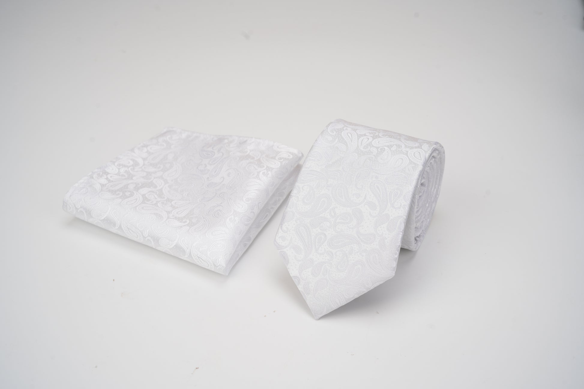 Two white pillows with textured surface on a light gray background