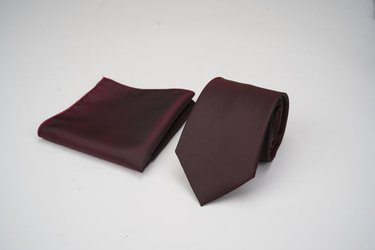 Burgundy tie and pocket square set on a white background