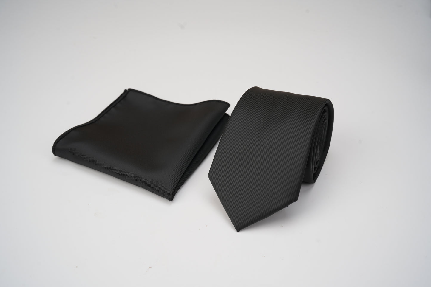 Black tie and black pocket square on a white background