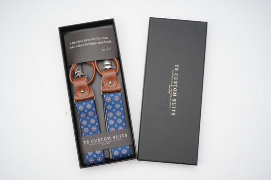 Blue patterned suspenders in a black box with 'TS Custom Suits' branding.