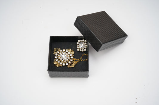 Black jewelry box with a brooch and necklace on a white background