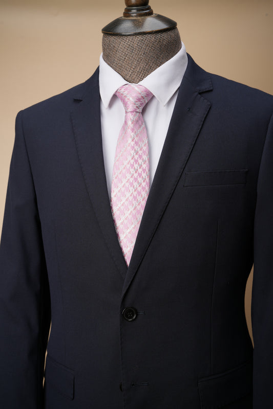 Navy suit jacket with a pink patterned tie on a mannequin against a beige background