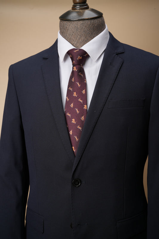 Navy suit jacket with a patterned tie on a mannequin against a beige background