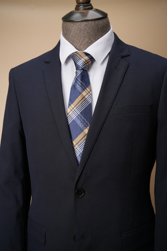 Navy suit jacket with a plaid tie on a mannequin against a beige background