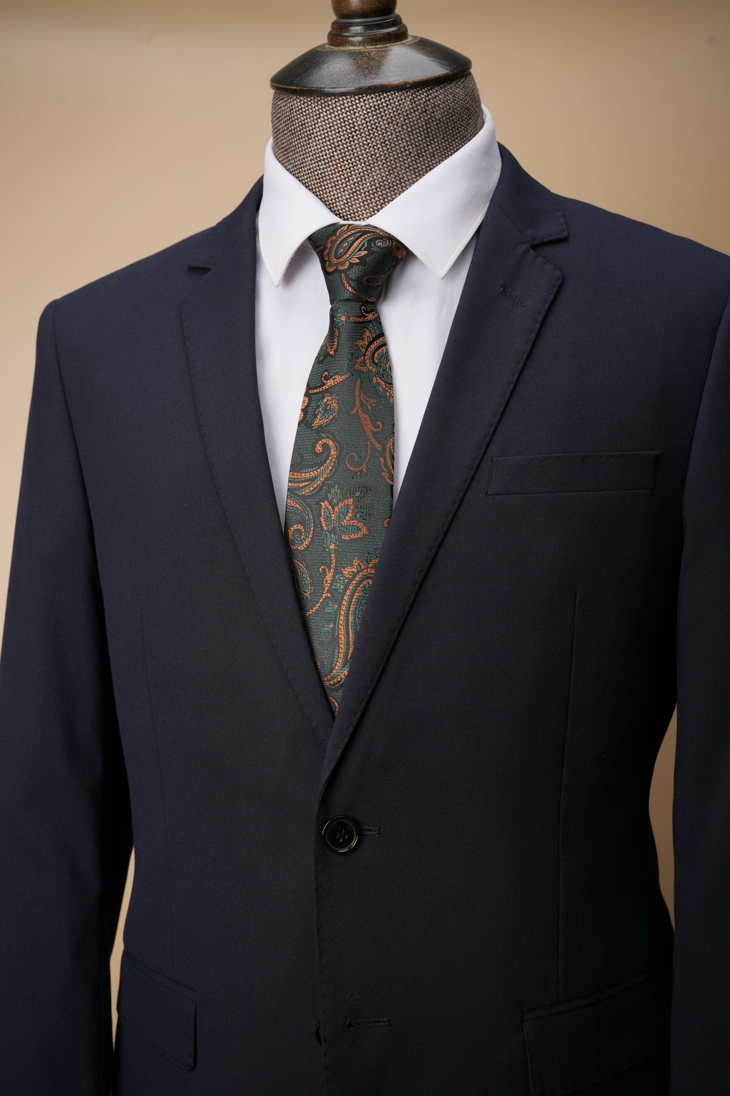Navy suit with a patterned tie on a beige background