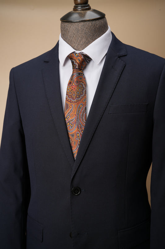Black suit jacket with a patterned tie in the pocket on a beige background