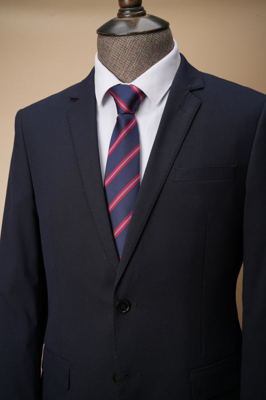 Navy suit with a red and blue striped tie on a mannequin against a beige background