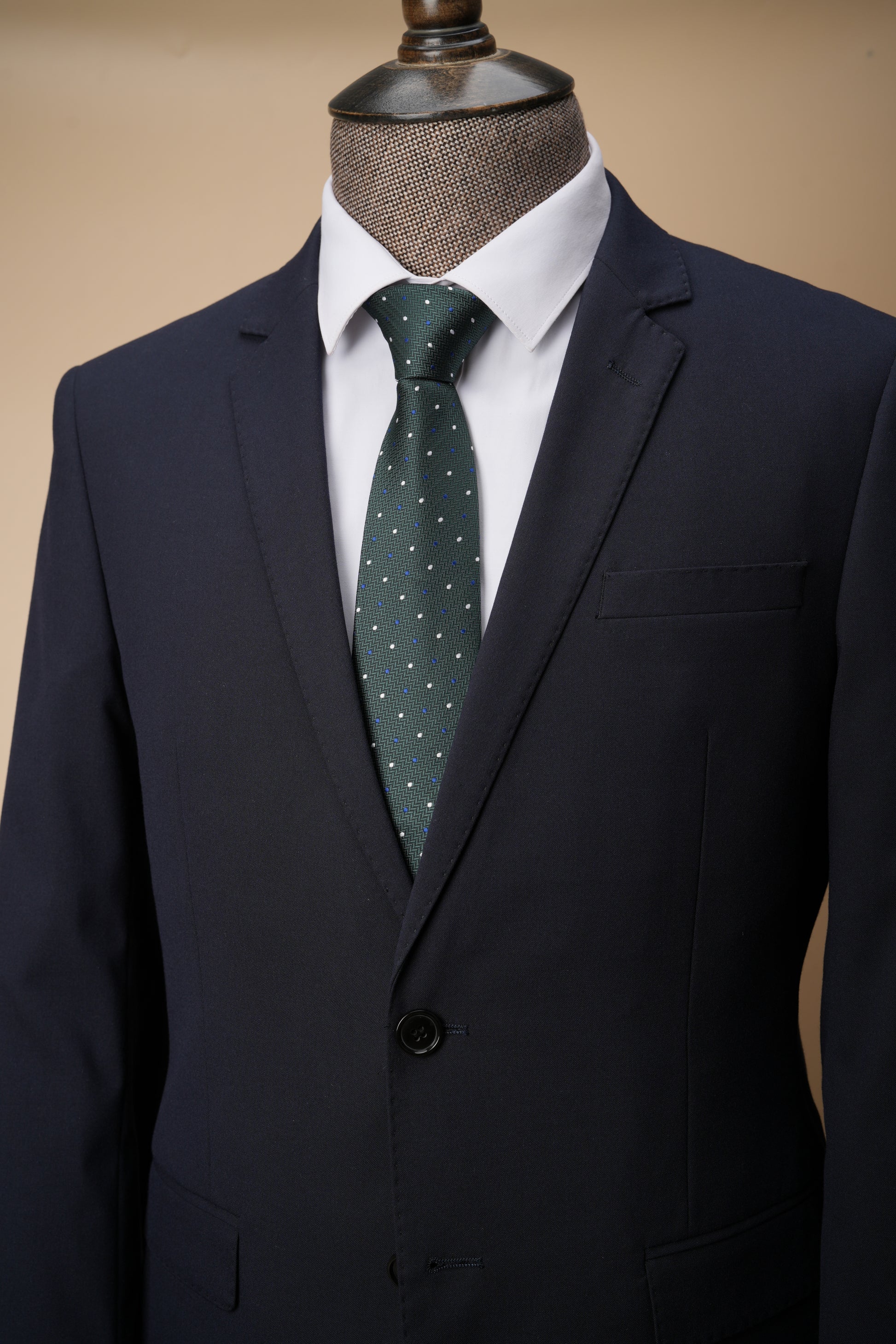 Green polka dot tie on a mannequin with a suit jacket