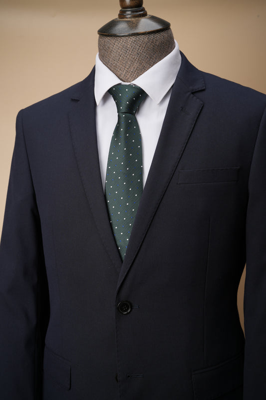 Green polka dot tie on a mannequin with a suit jacket