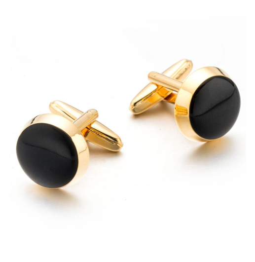 Gold cufflinks with black round stones on a white background