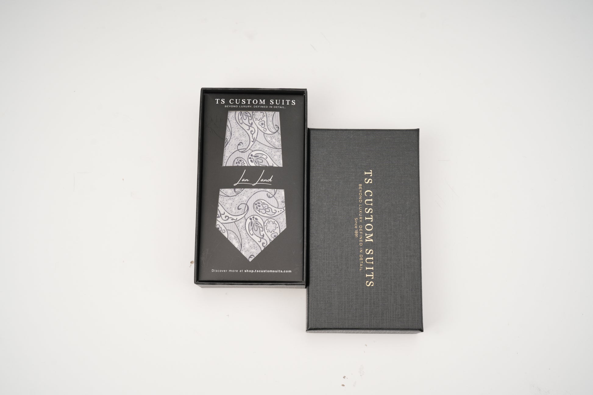 Gray box with a patterned tie inside on a white background