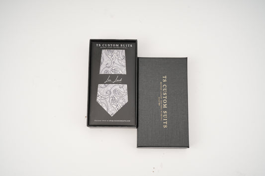 Gray box with a patterned tie inside on a white background