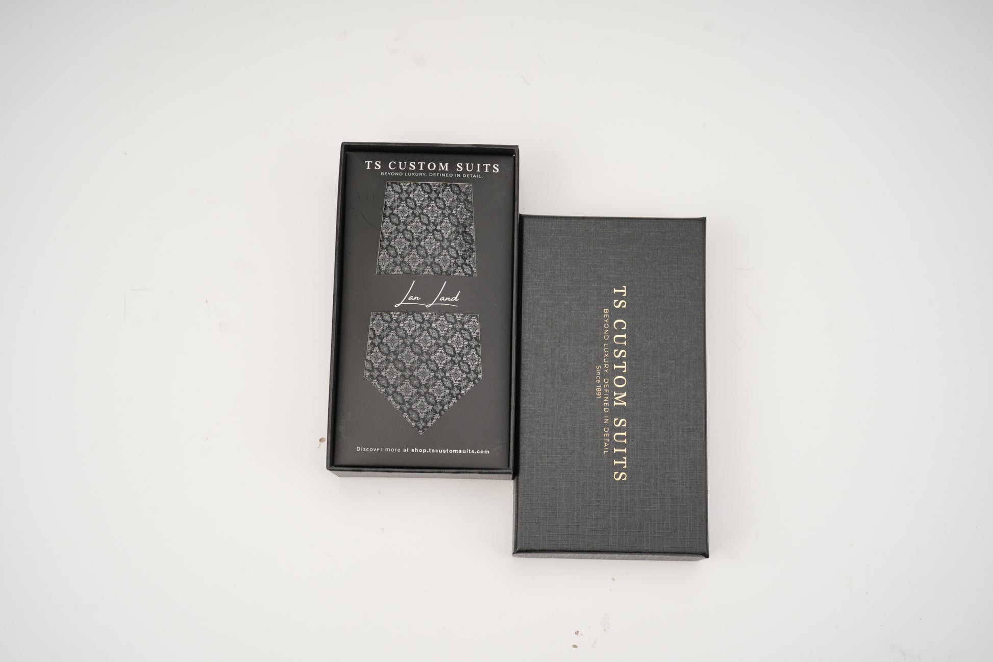 Gray box with a patterned tie inside on a white background