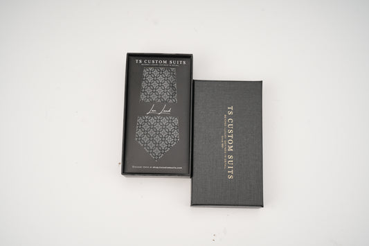 Gray box with a patterned tie inside on a white background