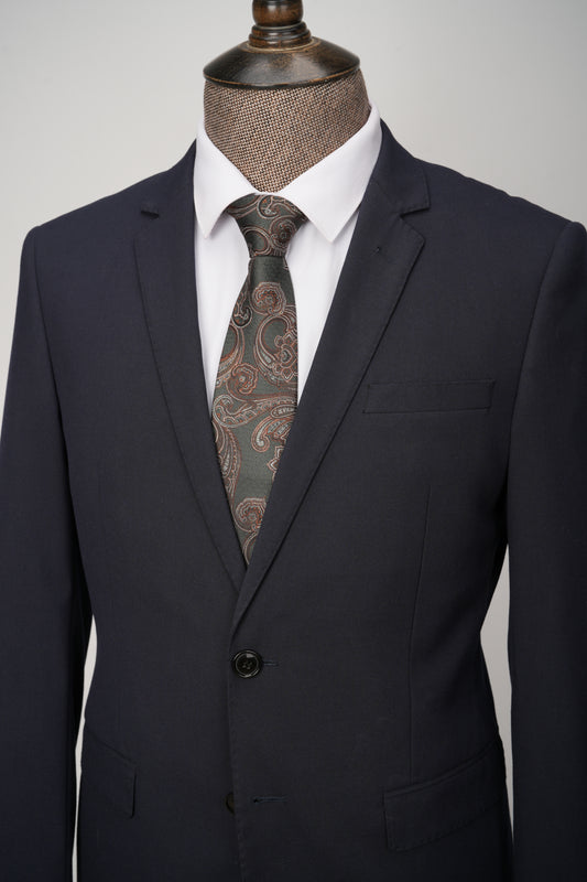 Black suit with a patterned tie on a mannequin against a gray background