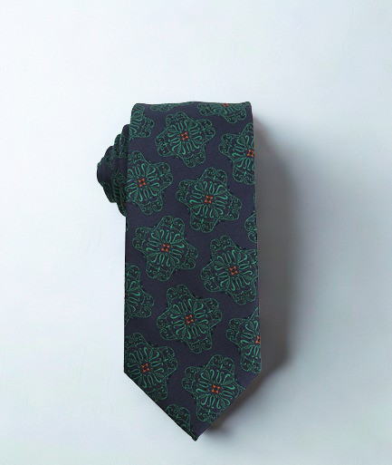 Navy tie with green floral pattern on a white background