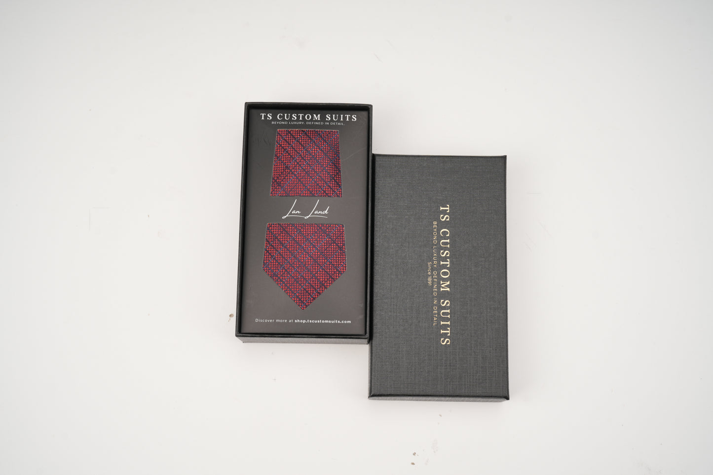 Red patterned tie in a 'TS Custom Suits' box on a white background