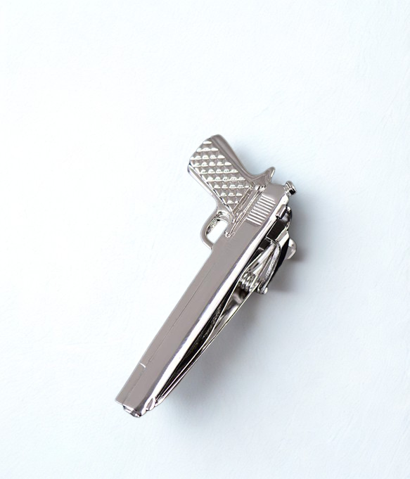silver tie bar with pistol shape.