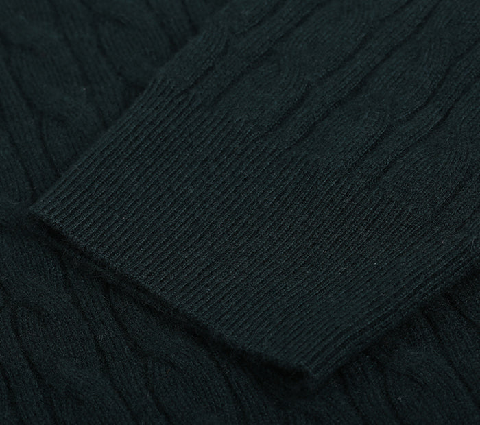 Close-up of the sleeve on a dark green cable knit cashmere sweater