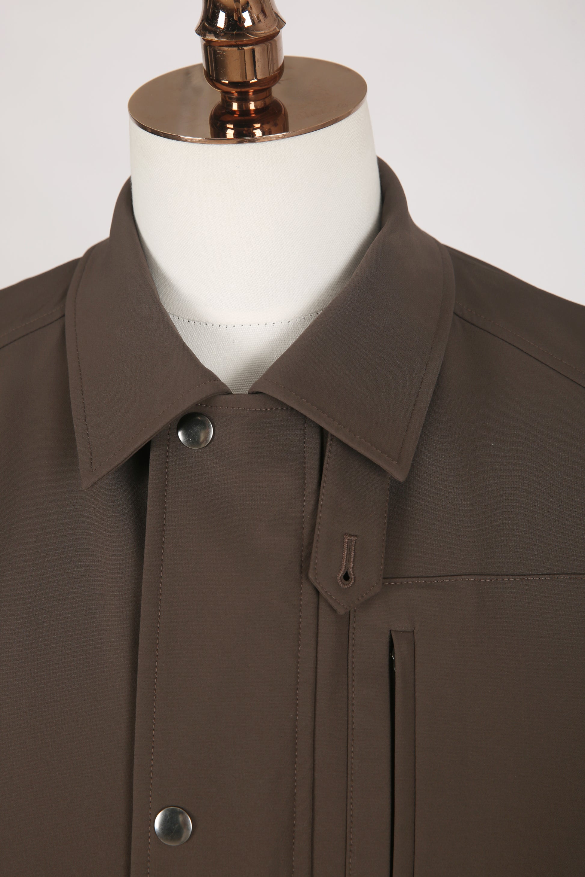 Brown coat on a mannequin with a white background