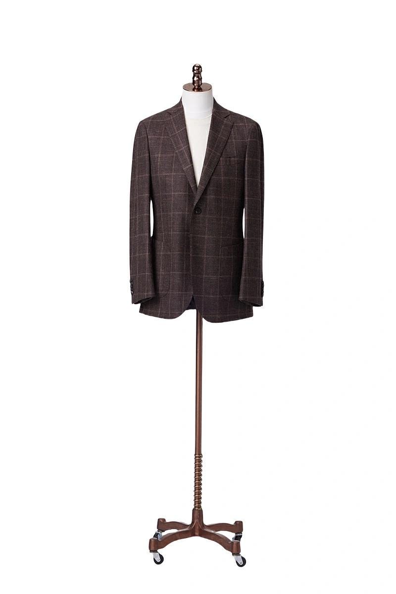 Brown checkered suit jacket on a wooden mannequin stand against a white background