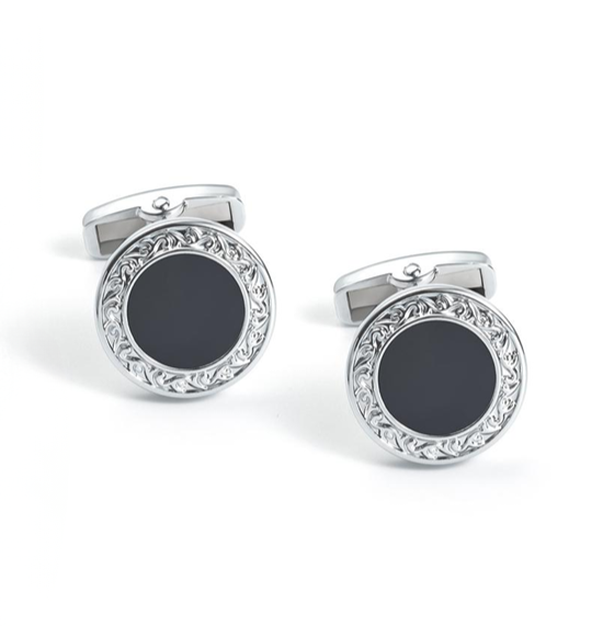 Pair of cufflinks with black centers and silver decorative rims on a white background