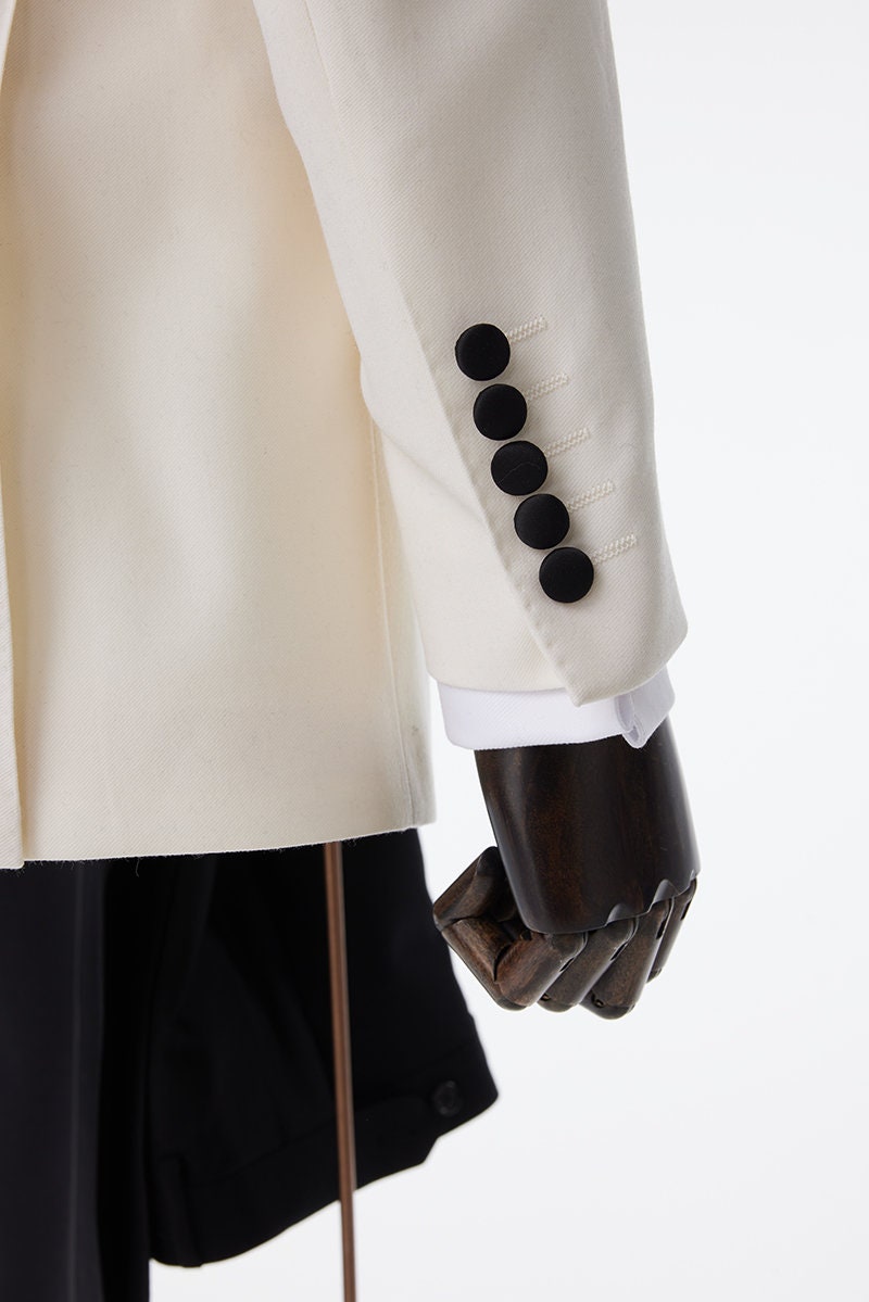 Ivory tuxedo with black shawl lapel. ivory wedding tuxedo. ivory off-white wedding tuxedo with black pants and a black satin accent stripe. Black satin lapel, satin covered buttons, black satin pocket accents on this ivory wedding tuxedo.