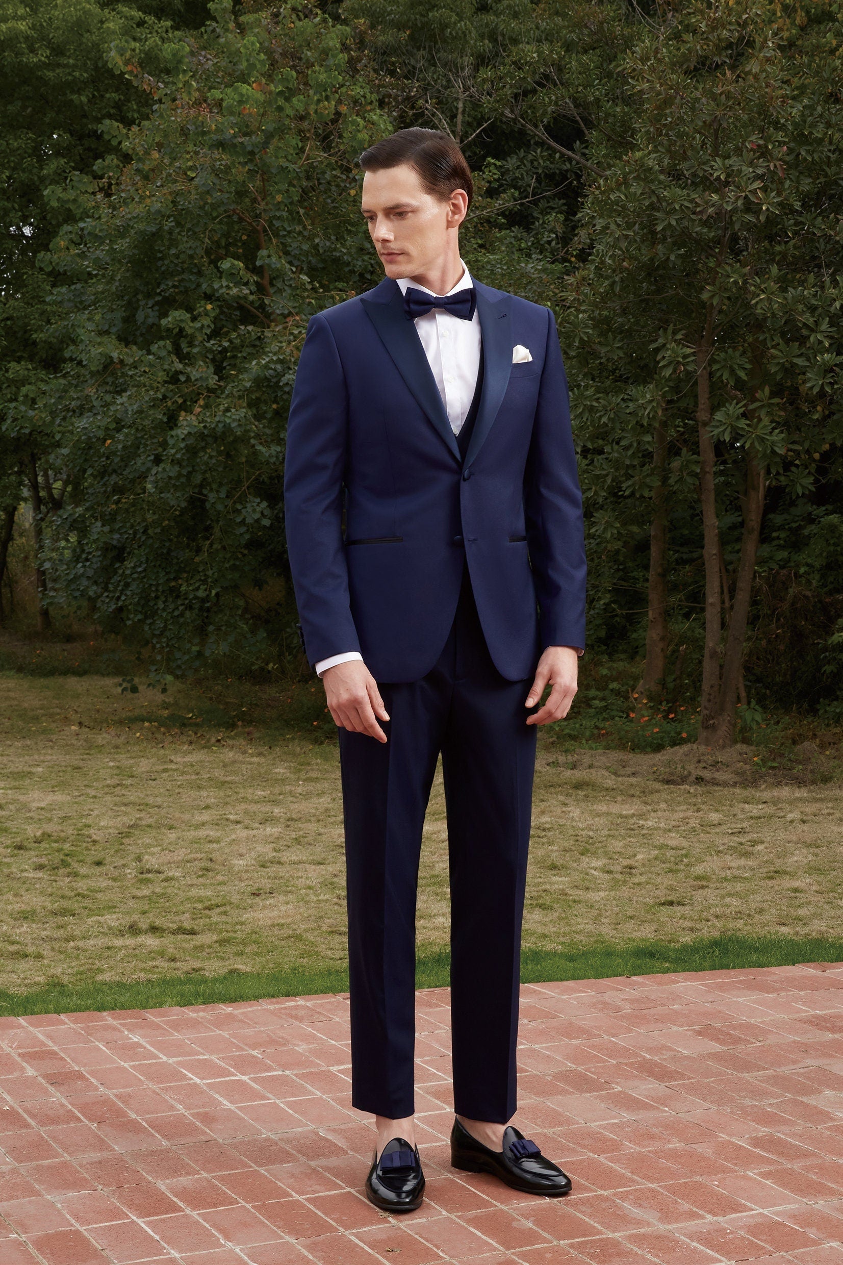 Navy wedding tuxedo with blue satin peak lapel. Single breasted navy tux with blue satin accents. 3-piece navy wedding tuxedo. Custom navy tuxedo for wedding.