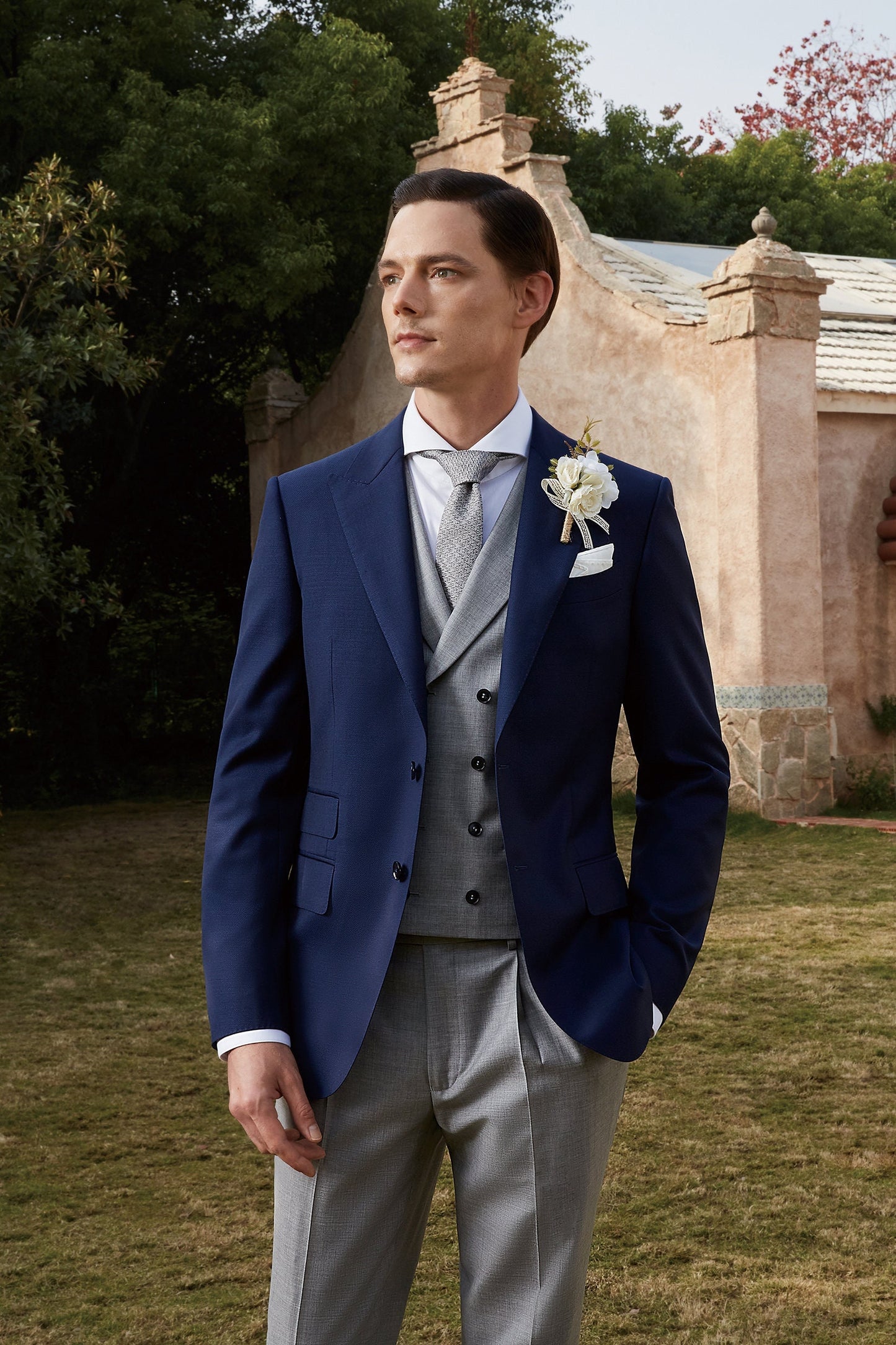 Blue wedding suit with peak lapel, a double breasted grey vest and grey pants. Blue and grey wedding suit. Blue wedding suit for groom. Grey wedding suit for groom. Blue suit with ticket pocket. Double breasted vest with shawl lapel.