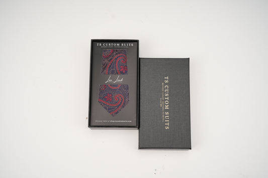 Gray tie box with a patterned tie inside on a white background