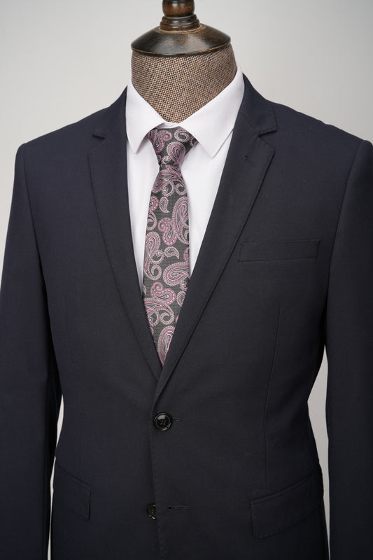 Black suit jacket with a white shirt and patterned tie on a mannequin against a gray background
