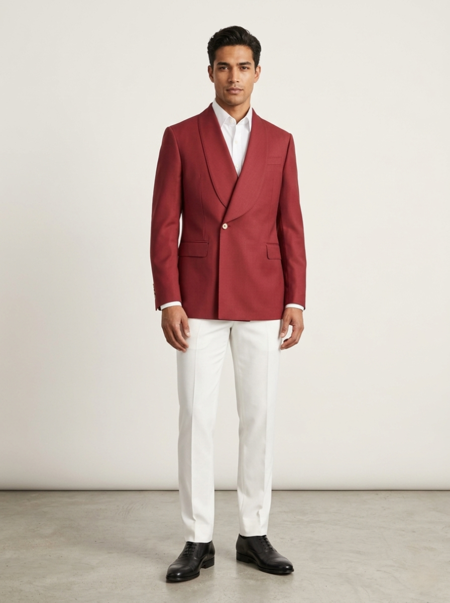 Man wearing a red blazer, white shirt, and white pants against a plain background