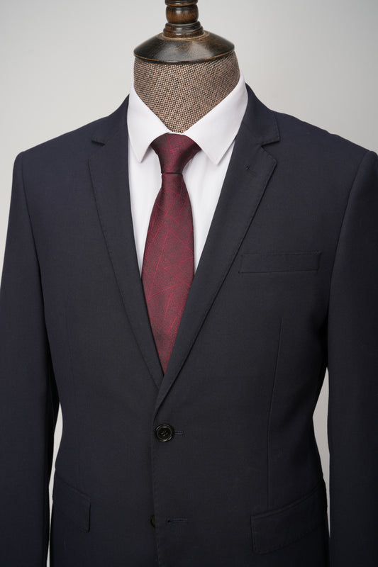 Black suit with a red tie on a mannequin against a gray background