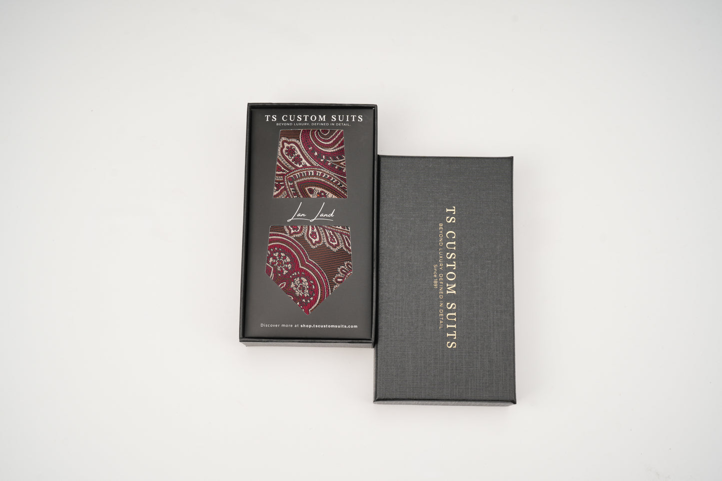 Two black boxes with red patterned ties inside, branded 'TS Custom Suits', on a white background.