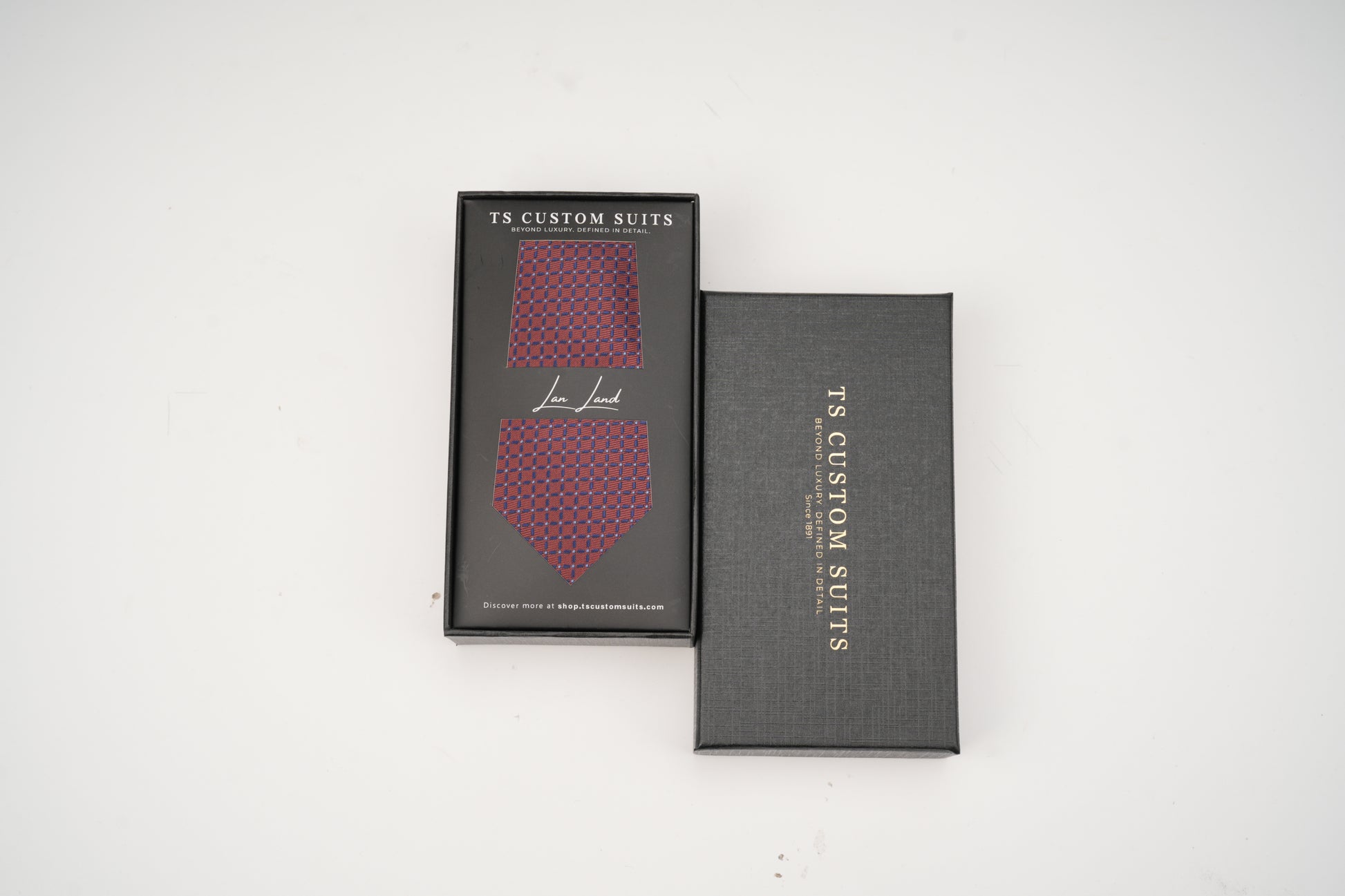 Two black boxes with red patterned ties inside, branded 'TS Custom Suits', on a white background.