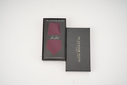 Two black boxes with red patterned ties inside, branded 'TS Custom Suits', on a white background.