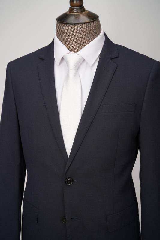 Black suit jacket on a mannequin with a white shirt against a gray background