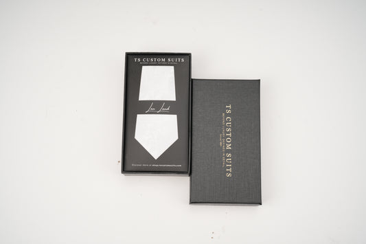 Gray box with a white tie design and 'TX Custom Suits' branding on a white background